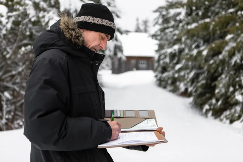 home Inspector taking notes during an inspection after snow storm